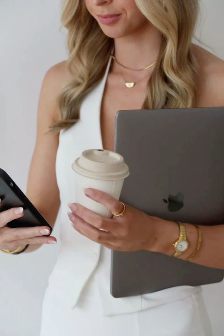 Founder of The Ninth Agency holding a laptop, coffee and phone